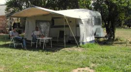 In de boomgaard van de groene camping in de Auvergne staat een caravan te huur, maar ook ruimte is voor tenten.